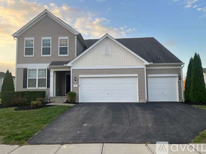 A two-story house with a garage and a driveway.