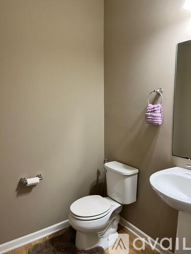 A white toilet sits next to a white sink in a bathroom.