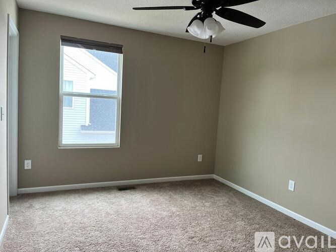 A room with a ceiling fan and a window.