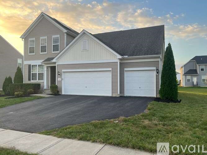 A two-story house with a garage and a driveway.