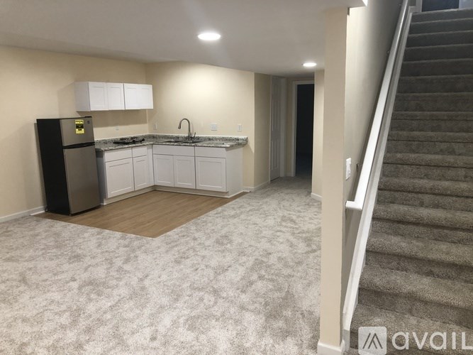 A kitchen with a refrigerator, sink, and cabinets.