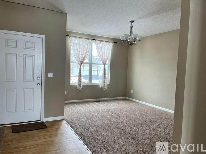 A room with a white door and a carpeted floor.