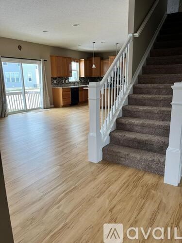 A spacious living room with a staircase leading to the upper floor.