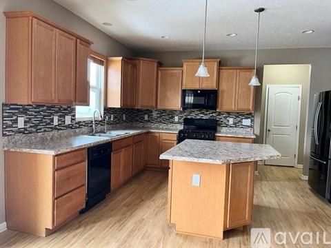 A kitchen with wooden cabinets and a granite countertop.