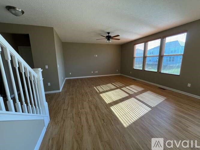 A room with wooden flooring and a ceiling fan.