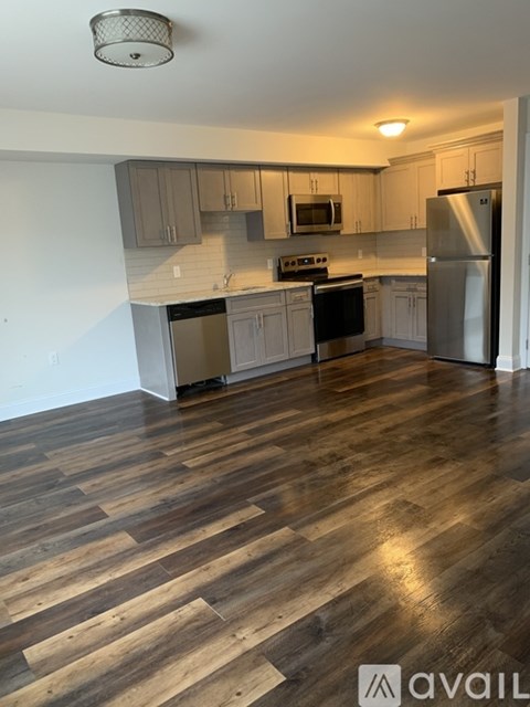 A kitchen with wooden floors and stainless steel appliances.