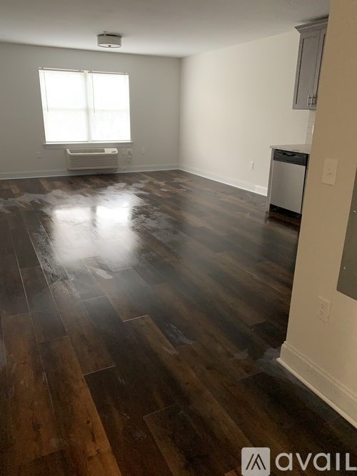 A room with wooden flooring and a window.