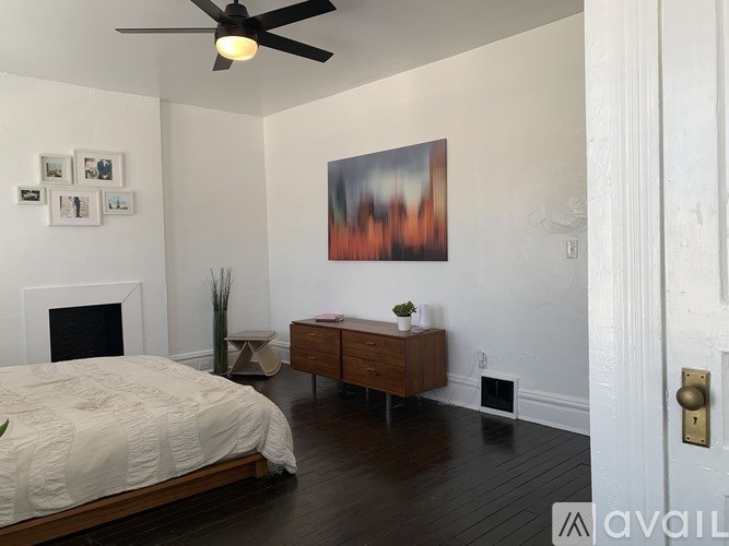 A bedroom with a bed, a dresser, and a painting on the wall.