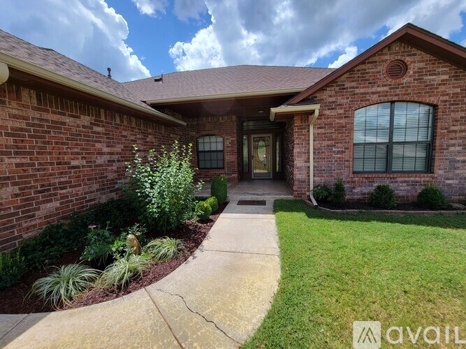 A house with a brick exterior and a front yard with plants.