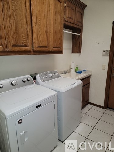 A white dryer and washer are in a small laundry room.