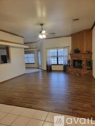 A living room with a fireplace and a ceiling fan.