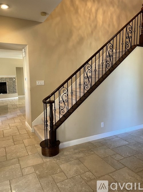 A staircase with a metal railing and a tiled floor.