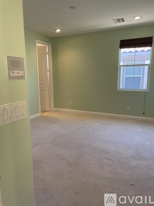 A room with a window and a door is available for rent.