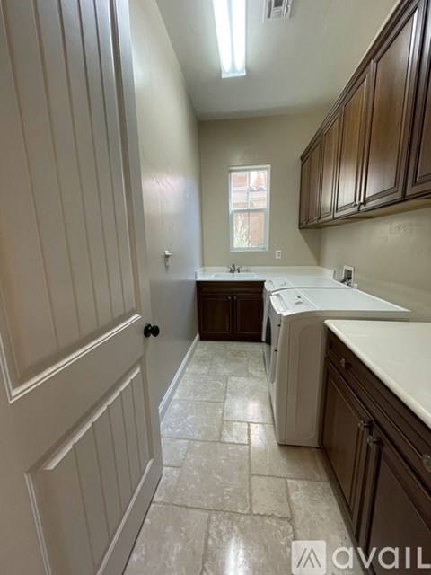 A kitchen with white cabinets and a washing machine.