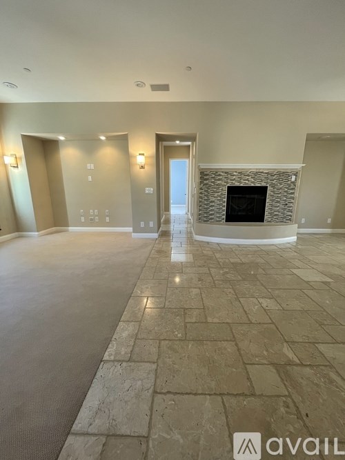 A spacious living room with a fireplace and tiled flooring.