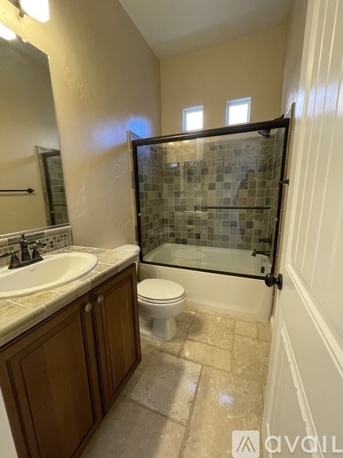 A bathroom with a toilet, sink, and shower.