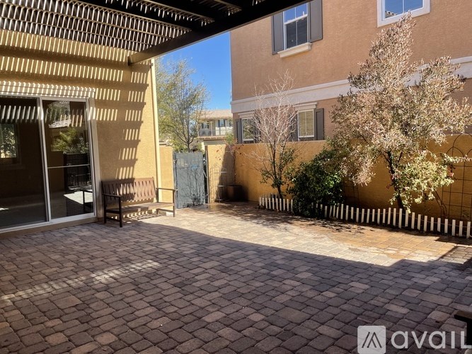 A patio with a bench and a table under a roof.