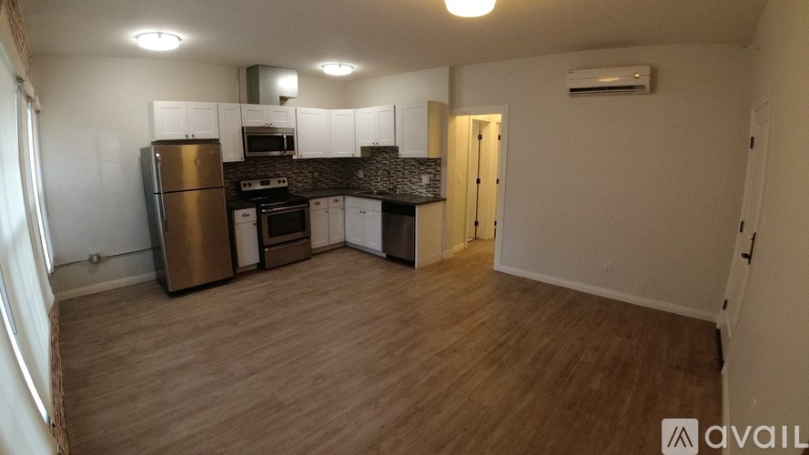 A kitchen with wooden floors and white walls.