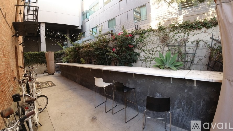 A patio with a table and chairs is surrounded by a brick wall and a bicycle.