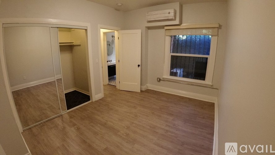 A room with a window and a door leading to another room.