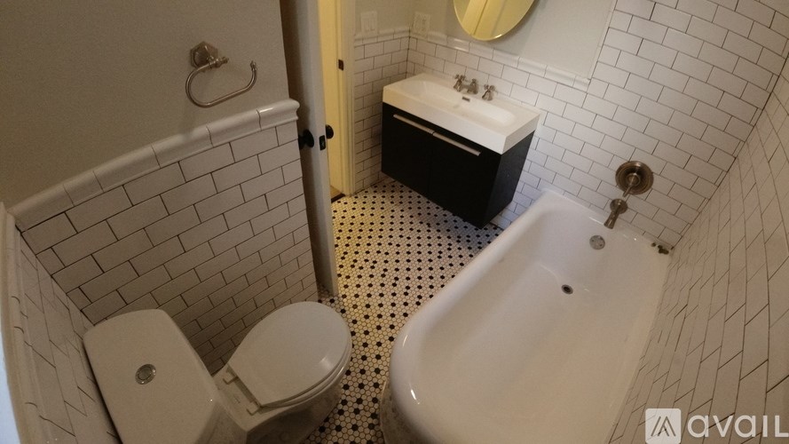 A bathroom with a toilet, sink, and bathtub.