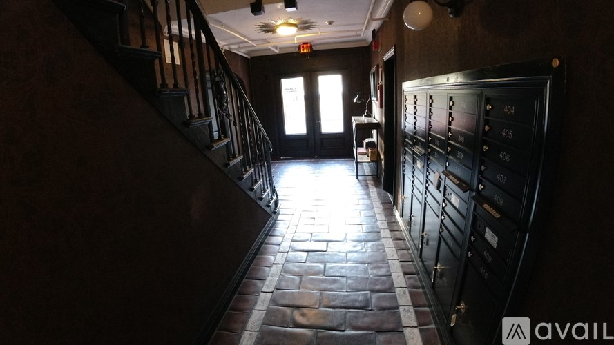 A hallway with a staircase on the left and a door on the right.