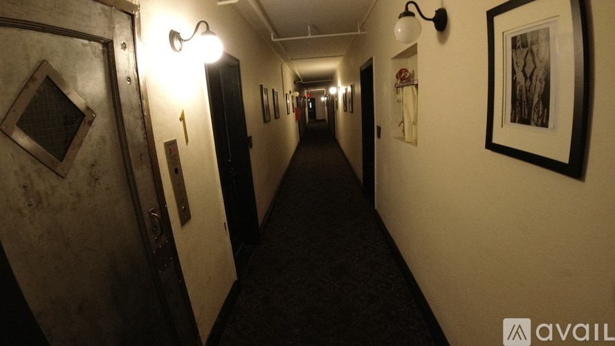 A long hallway with lights on the side and doors on the other.
