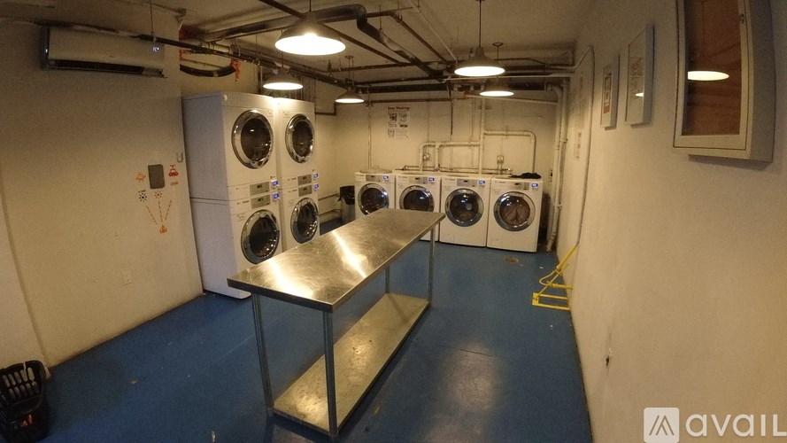 A laundry room with washing machines and a metal table.