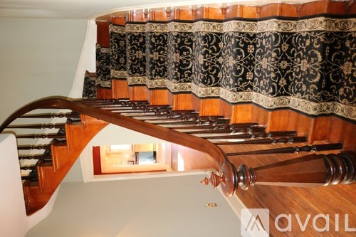A wooden staircase with a black and gold patterned runner.