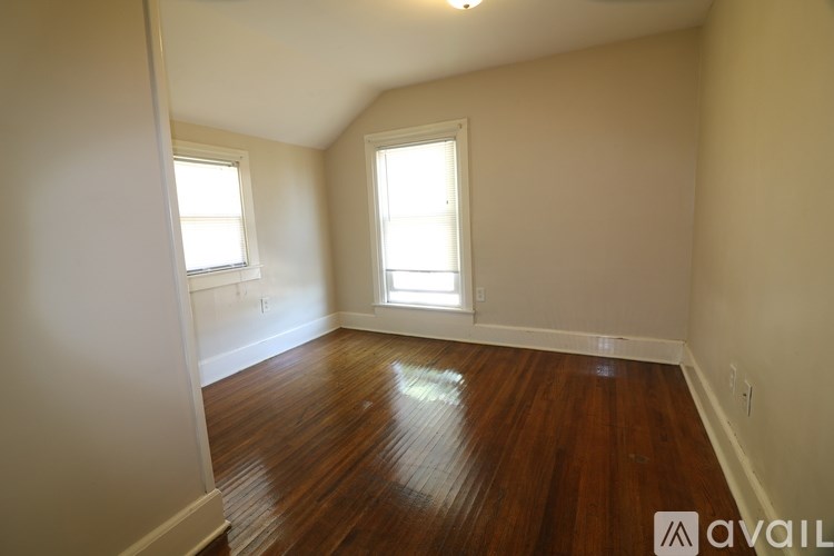 A room with wooden floors and two windows.