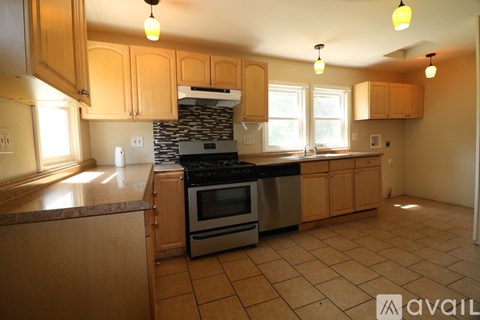 A kitchen with wooden cabinets and a stone backsplash.