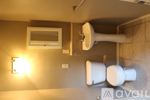 A bathroom with a toilet, bidet, and mirror.
