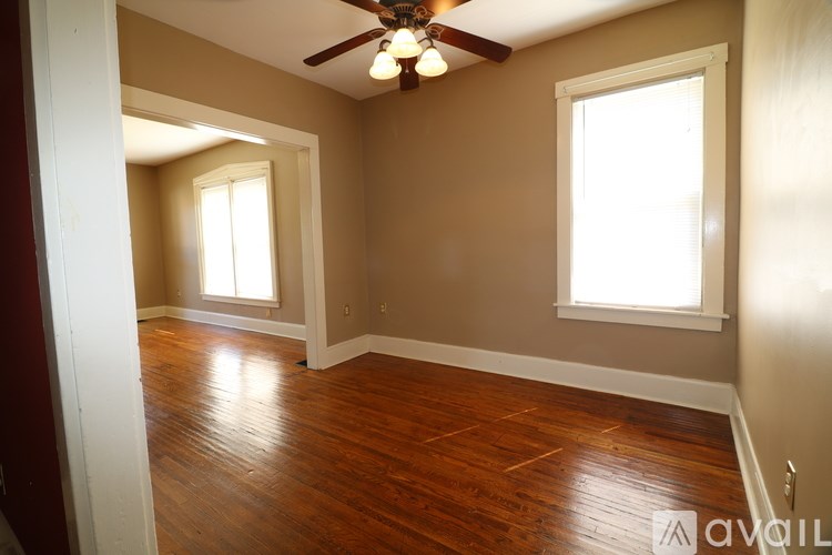 A room with wooden floors and a ceiling fan.
