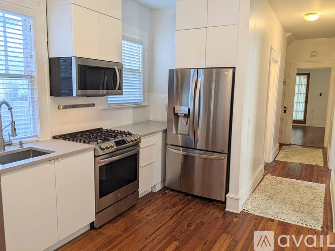 A kitchen with a stove, refrigerator, and microwave.