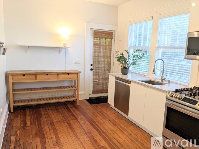 A kitchen with wooden floors and white cabinets.