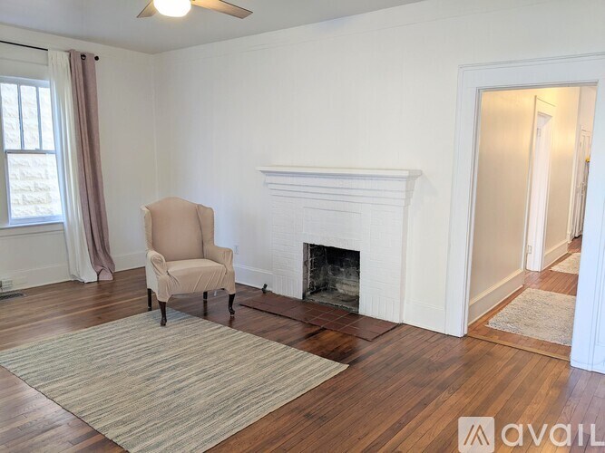 A living room with a fireplace and a chair.