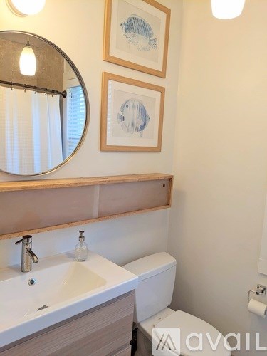 A bathroom with a sink, toilet, and two wall-mounted light fixtures.