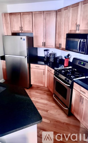 A kitchen with wooden cabinets and black countertops.