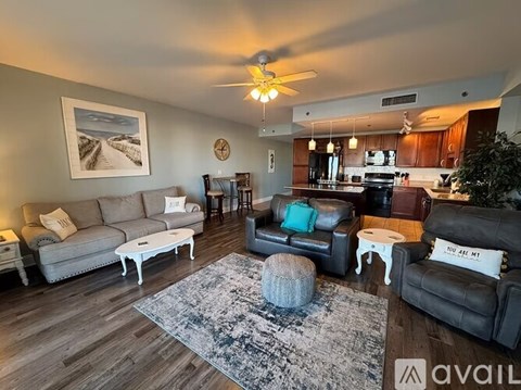 A living room with a grey couch, a white coffee table, and a rug with a snowy design.