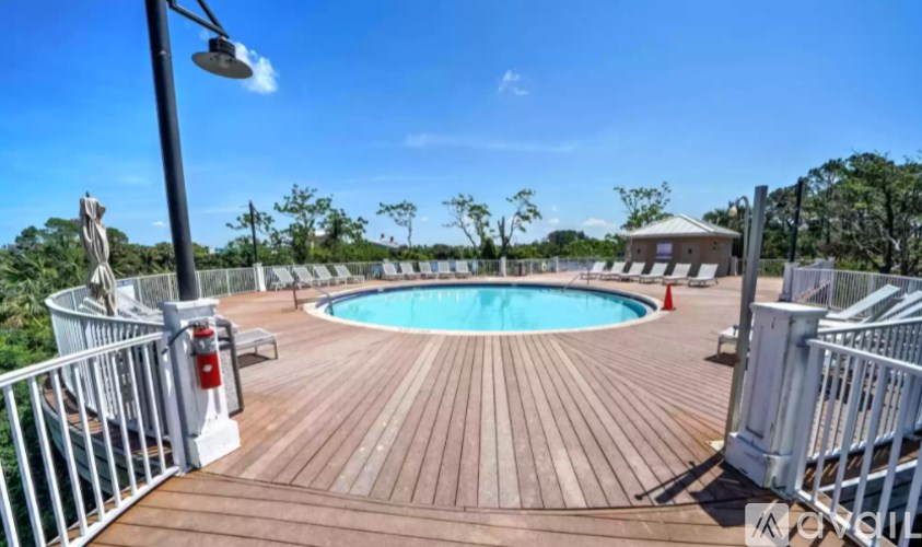 A wooden deck with a pool and a white railing.