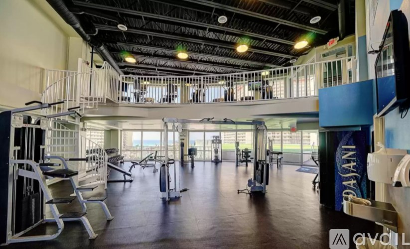 A gym with a variety of equipment including treadmills, weights, and exercise machines.
