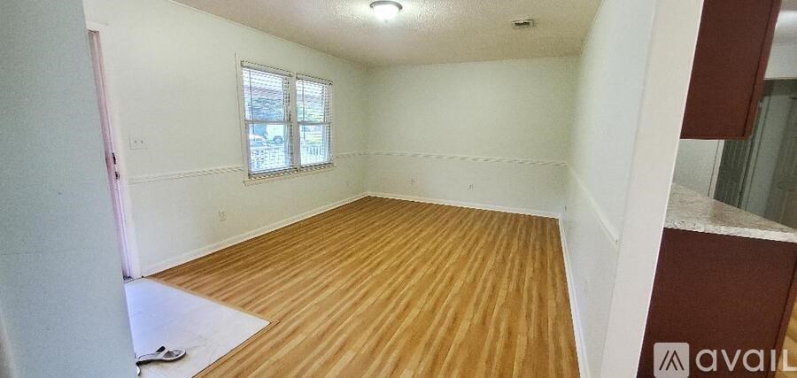 A room with wooden flooring and a window.