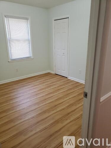 A room with wooden flooring and a white door.