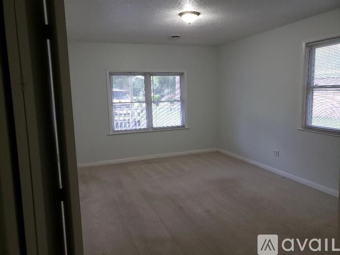 A room with a window and a wooden floor.