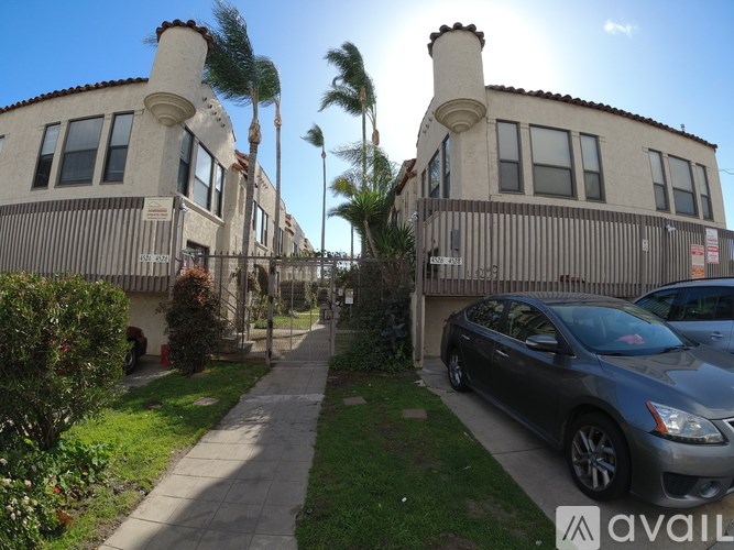 A car is parked in front of a building with a sign that reads "AVAIL".