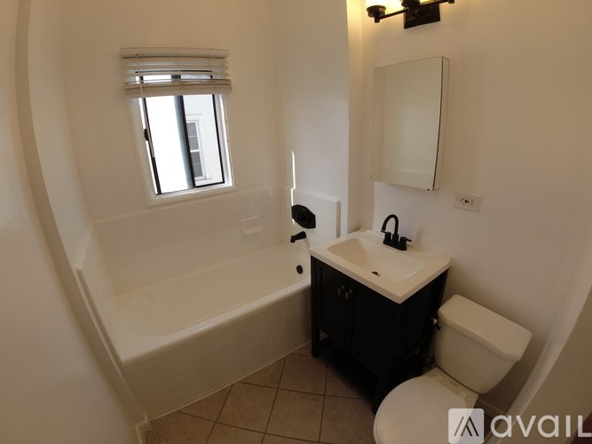 A bathroom with a tub, toilet, and sink.