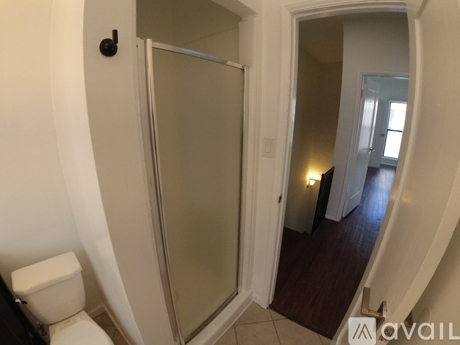 A bathroom with a toilet and a glass door.