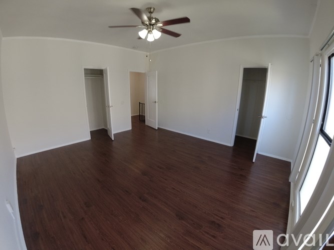 A room with wooden floors and a ceiling fan.