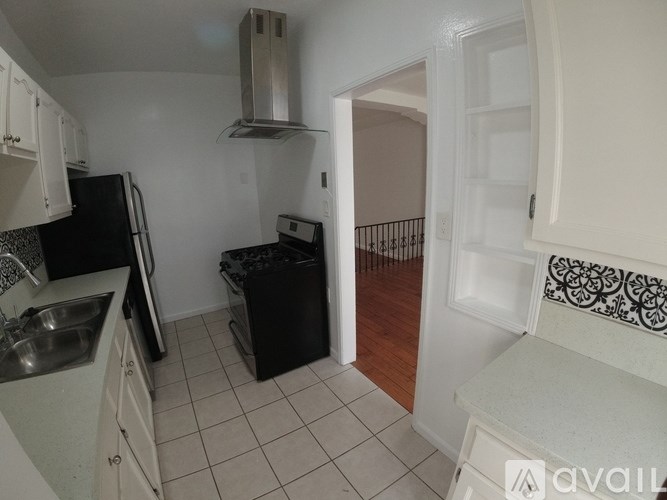 A kitchen with black appliances and white cabinets.