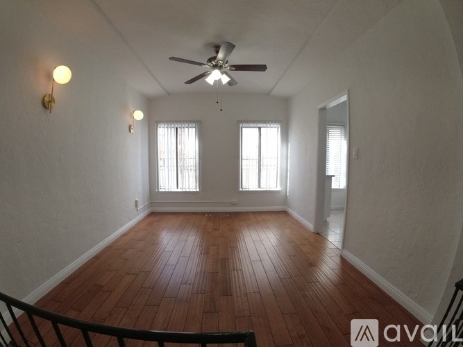 A room with wooden floors and a ceiling fan.